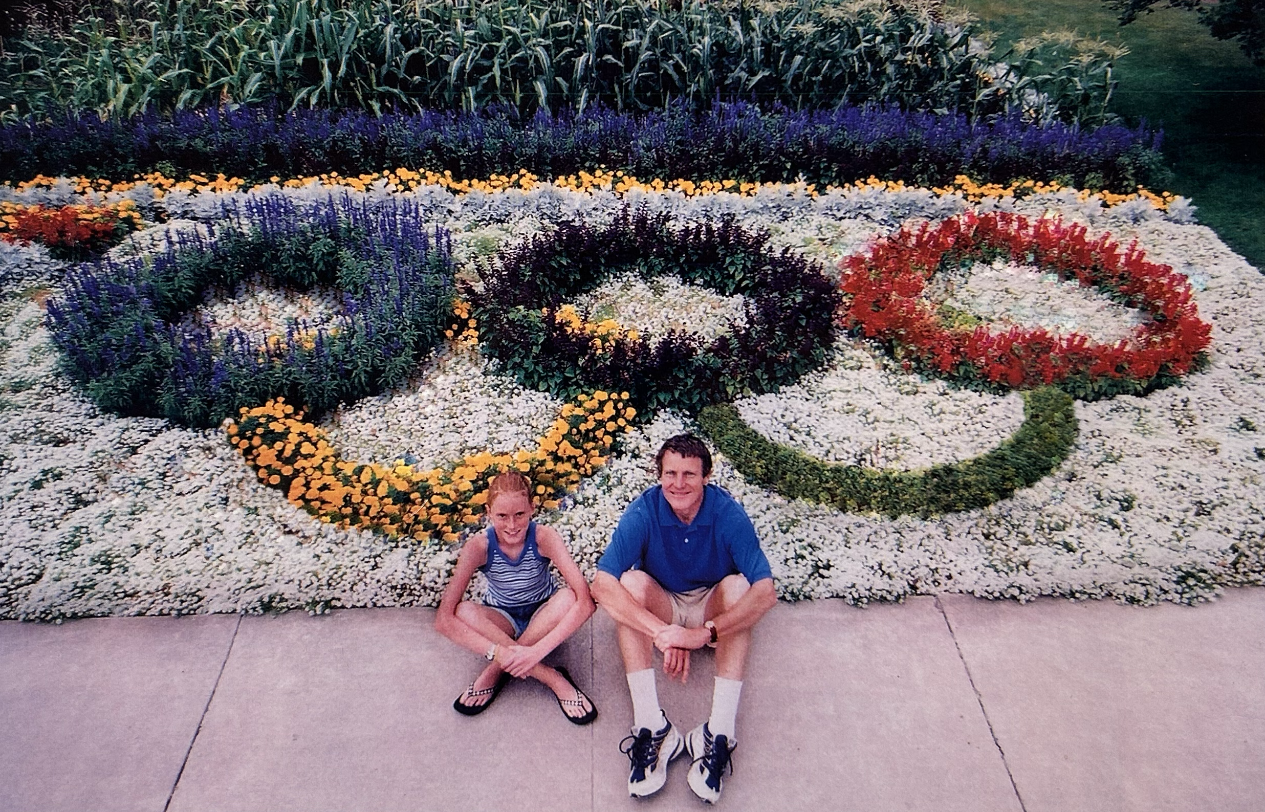 Bruce and Anna Bugbee seated in front of the Olympic rings flower design